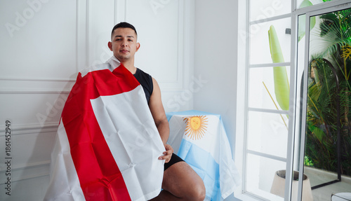Fotografie Smiling young athlete holding the English flag while looking at the Argentinian