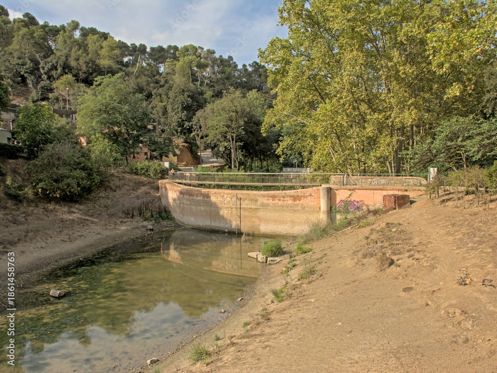 Fototapeta premium Pantano De Vallvidrera water reservoir, almost dried out in summer, in Sierra de Colserolla mountains. Barcelona, catalonia, spain 