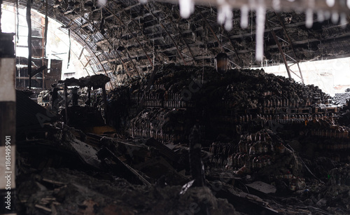 Εκτύπωση καμβά Burned warehouse interior with collapsed roof and stacks of melted plastic bottles, depicting industrial fire damage and destruction