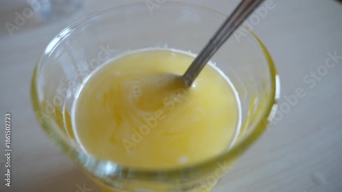 Effervescent Supplement Powder Dissolving in Glass of Water. Stirring with Spoon Close-up