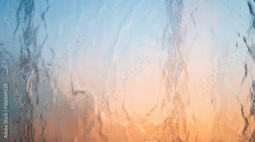 Warm sunset light reflecting through hammered glass texture with blue sky tones