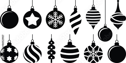 Black and white Christmas ornaments hanging on strings .