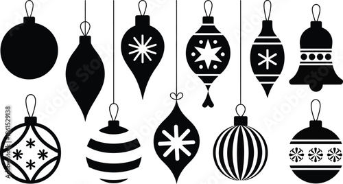 Black and white Christmas ornaments hanging on strings .