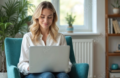 Young woman smiles while using laptop, sitting in armchair at home. She consults online via video call, working remotely. Virtual communication, tech, wellness, comfortable workspace. Free Download Young woman smiles while using laptop, sitting in armchair at home. She consults online via video call, working remotely. Virtual communication, tech, wellness, comfortable workspace. - GFXLoad