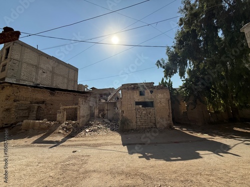 Φωτογραφία War-torn buildings stand in ruins under a clear sky, showing the devastation and impact on infrastructure