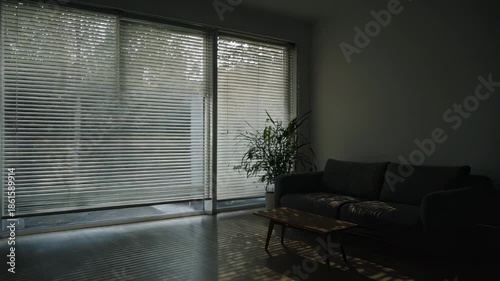Motorized venetian blinds closing in a modern living room