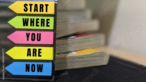 Φωτογραφία Colorful sticky notes with motivational message “Start Where You Are Now” beside books, symbolizing learning and personal growth