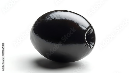 A glossy, single black olive rests against a white background, casting a soft shadow. The olive's surface reflects light