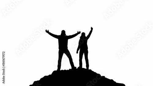 Two hikers celebrating on a mountain peak silhouette.