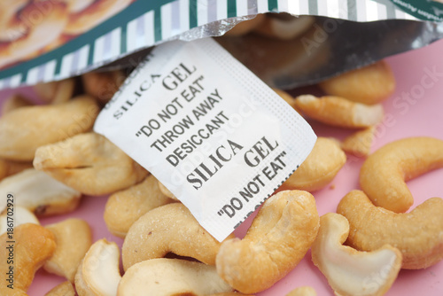 Φωτογραφία Cashews and silica gel packet on a pink surface