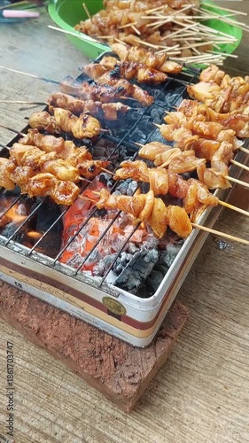 The pleasure of grilling chicken satay over hot coals