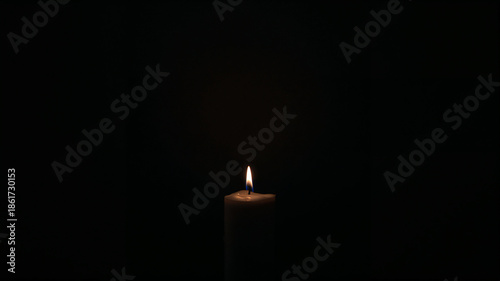 Candle in the Darkness: A lone candle, its flame flickering gently against a black canvas, casts a warm, inviting glow, creating a poignant ambiance.