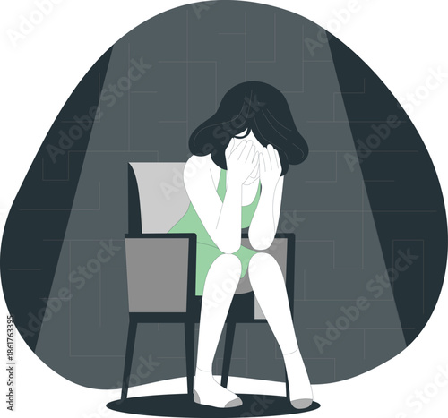 A woman sits alone in a chair, her face hidden by her hands, in a dimly lit room