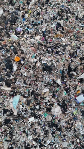 4K Vertical aerial view ascending over massive urban garbage landfill