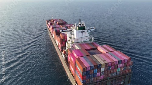 4K Aerial top view of a loaded container cargo vessel traveling over ocean