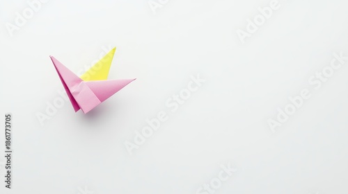 Free Download Delicately Folded Pink and Yellow Origami Boat Resting on a Minimalist Light Gray Surface - GFXLoad