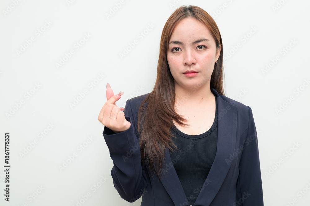 Obraz premium Portrait of a young Asian businesswoman against white background showing mini finger heart gesture