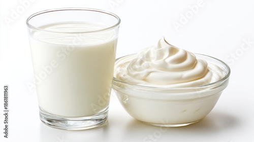 A clear glass holds wholesome milk beside a small bowl filled with velvety yogurt. The clean white background highlights the simplicity and freshness of these dairy delights