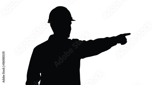 Silhouette of a construction worker wearing a safety hard hat pointing decisively toward the right side in a stark high contrast isolated studio setting
