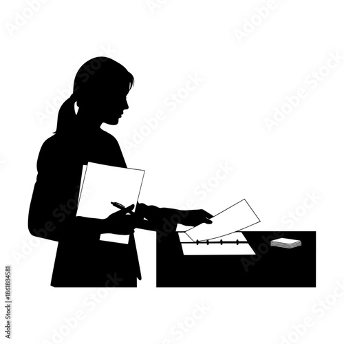 Silhouette of businesswoman organizing documents at desk in office environment.