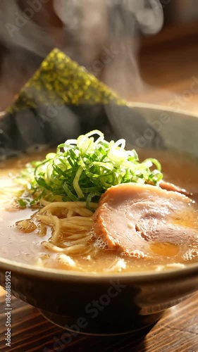 Steaming bowl of ramen noodle soup with sliced pork, green onion, seaweed and savory broth. steaming ramen bowl with noodles, scallion and pork rich