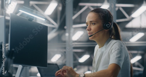 Fotografía Female Operator Providing Remote Technical Assistance While Speaking on Headset in Setting Modern Enterprise Control Center