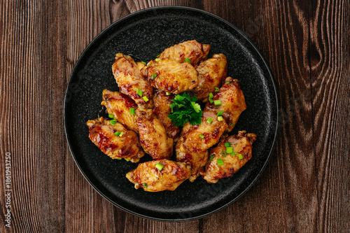 Delicious Roasted Chicken Wings with Rosemary on a Wooden Table