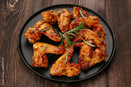 Delicious Roasted Chicken Wings with Rosemary on a Wooden Table