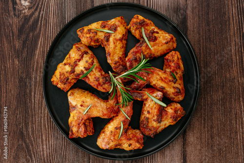 Delicious Roasted Chicken Wings with Rosemary on a Wooden Table