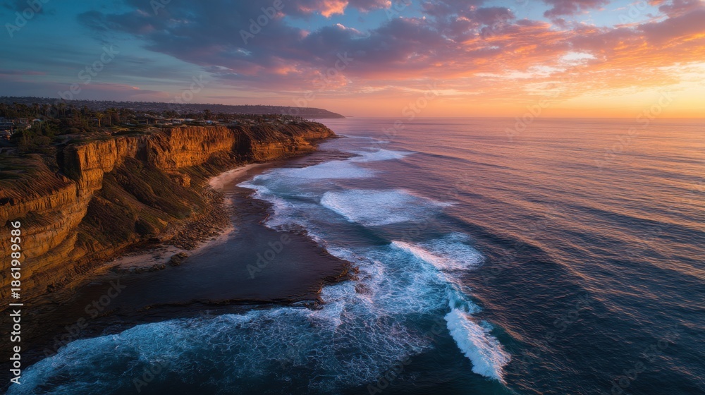 Fototapeta premium Stunning coastal sunset over rocky cliffs and ocean waves.