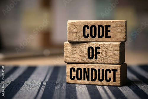 Code of conduct wooden blocks stacked on rustic table, business ethics compliance standards concept.