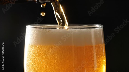 Wallpaper Mural Close up shot of golden beer pouring from a bottle into a clear glass, creating a rich head of foam. Torontodigital.ca