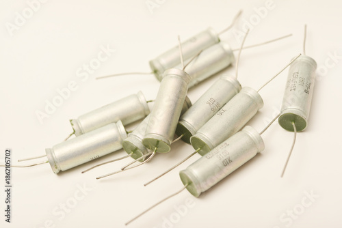 Old capacitors in paper packaging. Aluminum capacitors on a white background. Electronic components.