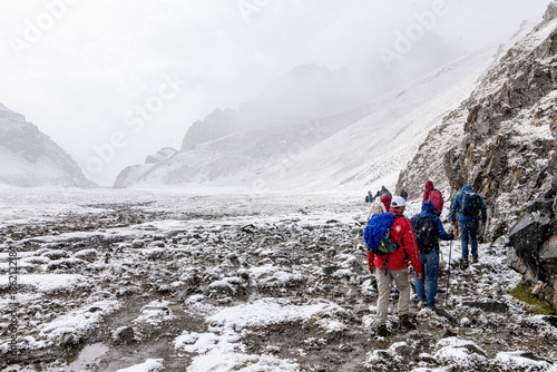 Foto A group of tourists with backpacks are marching along a snowy mountain trail