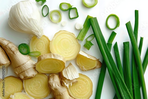 Assorted vegetables and roots sliced on a white background.