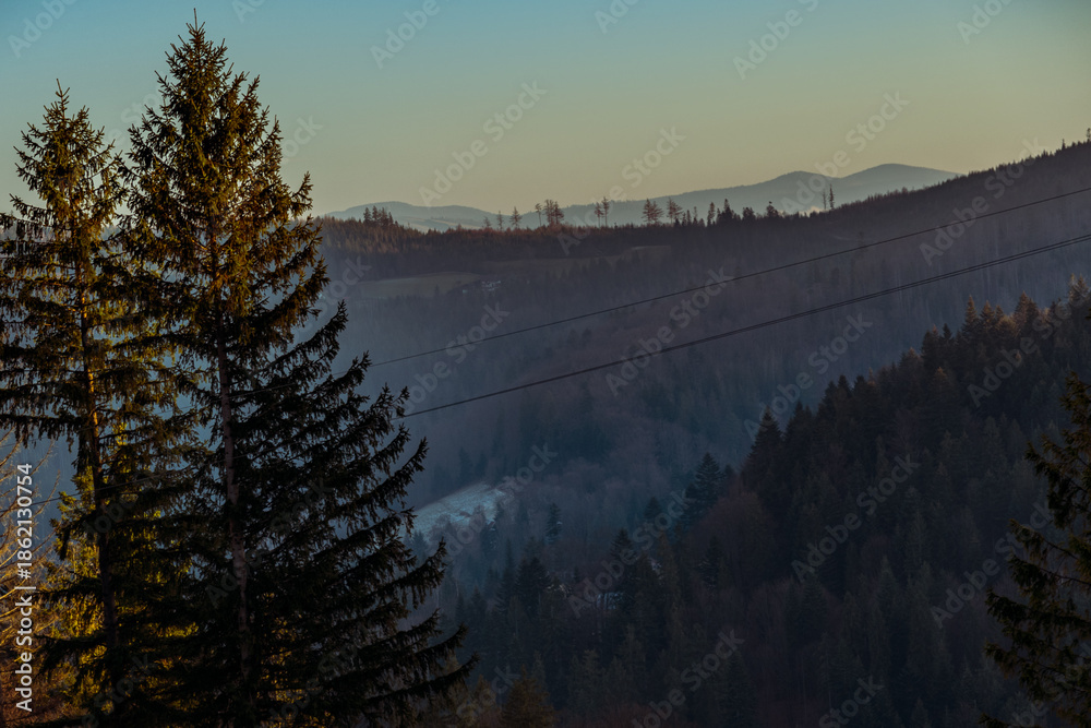 Obraz premium Scenic mountain landscape at sunset, warm sky colors, natural light, and a peaceful atmosphere. A perfect scene capturing the beauty of mountains during golden hour.