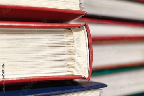 Close-up of stacked photo albums with red covers, showing page edges and binding detail.