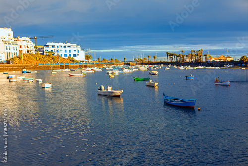 Natural seawater lagoon Charco de San Gines located in Arrecife, Lanzarote, Canary Islands, Spain. Atlantic due to fishing boats that bob on water, surrounded by traditional white fishermen cottages