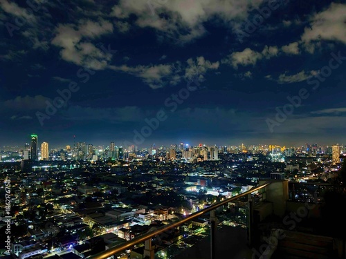 Wallpaper Mural Panoramic Night View of a Metropolis Skyline with Glowing City Lights Under Cloudy Sky Torontodigital.ca
