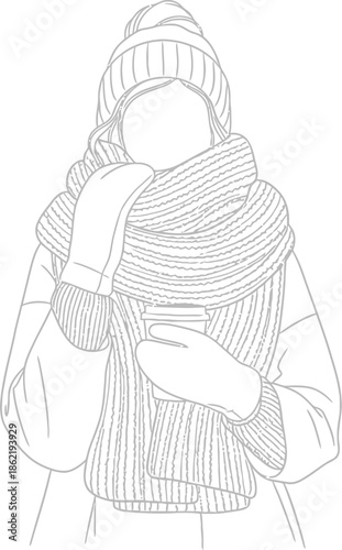 Woman bundled up warmly in winter attire wearing a knit hat and thick scarf while holding a disposable cup of a hot beverage outdoors.