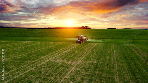 Bild auf Leinwand farmer working in the field on a tractor until sunset