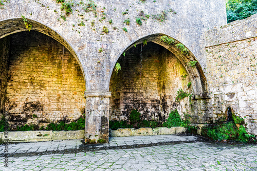 Gothic ogival arches of the medieval Fonte di Docciola with the historic washhouse below, in Volterra, province of Pisa, Tuscany region, Italy.