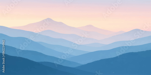 Misty blue mountain range at dawn with a forest valley under a foggy sunrise sky and sun peeking over the peak horizon