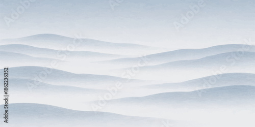 An aerial view of a bright blue sky with white clouds over cold winter mountains and a snow landscape