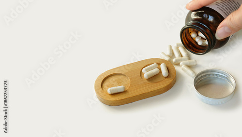 Spilled pills, medicine dosage tray, bottle in hand. Medicine dosage, prescription medicine, food supplement tablets, beauty pills, pain killers. Placebo effect. Pharmacy business. Bowel cleansing