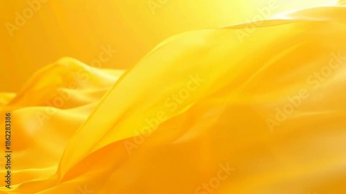 Abstract yellow fabric background with soft, gentle folds, creating a smooth, flowing texture.