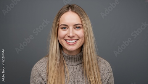 Portrait of a Woman Smiling Against a Plain Background in a Sweater, Captured...