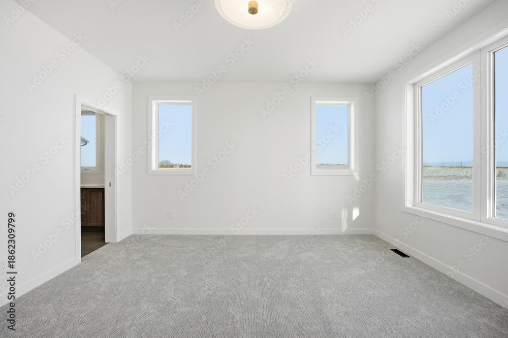 Obraz premium Large, empty room with a white door and two windows