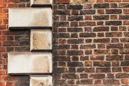Textured red and brown brick wall with large stone architectural detailing