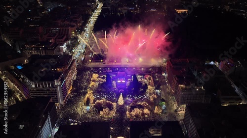 Aerial drone cinematic video of illuminated festive Syntagma square featuring firework show and Christmas tree during New Year's Eve, Athens centre, Attica, Greece